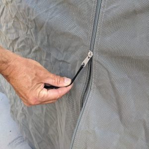 A hand is pulling down the zipper to close our easy-to-use camper cover.