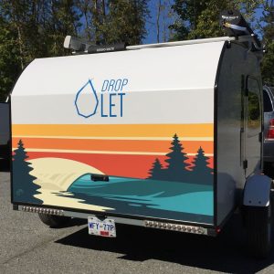 Artwork on the back of a trailer paints a beautiful scene of nature with a shore, water, and trees.